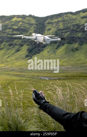 Quadcopter ou drone en vol contre le ciel. Un petit drone décolle de la main d'une personne. Banque D'Images