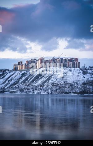 Belle vue d'un quartier résidentiel d'immeubles d'appartements un soir d'hiver sur les rives de la rivière Ienisei à Krasnoïarsk, Russie. Un BE Banque D'Images