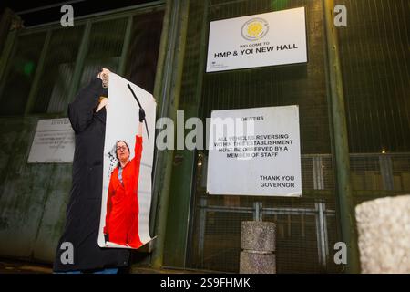 Wakefield, Royaume-Uni. 25 JANVIER 2025. La bannière de Francesca Nadin tenant une pioche sur le toit de Teledyne est tenue devant les portes alors que les manifestants tenaient une manifestation dans les locaux de Womens et YOI HMP New Hall près de Wakefield, la police n'a pas tenté d'empêcher les quelque 100 manifestants de marcher sur l'allée principale, les manifestants ont chanté joyeux anniversaire au prisonnier incarcéré de Palestine action Fransceca Nadin, qui aurait pris des mesures contre Barclays Bank et contre Teledyne à Shipley. Les manifestants ont frappé des tambours et frappé les murs de la prison avant de déclencher des feux d'artifice. Crédit Milo Chandler/Alamy Live News Banque D'Images