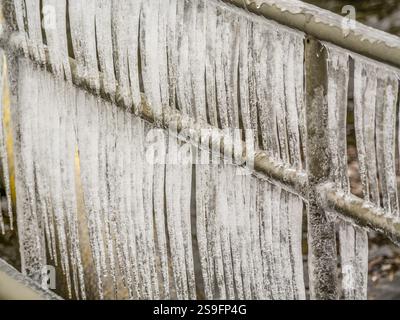 Des glaçons se sont formés le long d'une balustrade en acier en raison du froid, symbolisant la beauté rude de de l'hiver. Banque D'Images