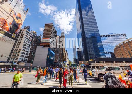 Passage piétonnier très fréquenté près de Madison Square Garden avec Empire State Building visible sur le ciel bleu. New York. ÉTATS-UNIS. Banque D'Images
