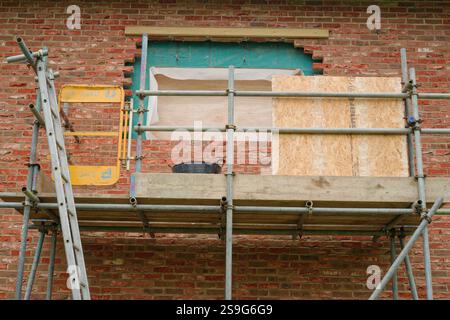 Construire ceux qui possèdent leur maison. Travaux de construction de maisons. Construction d'un bâtiment en bois avec revêtement en brique. Banque D'Images