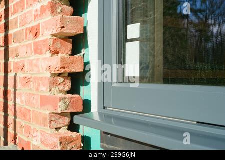 Construire ceux qui possèdent leur maison. Travaux de construction de maisons. Construction d'un bâtiment en bois avec revêtement en brique. Banque D'Images