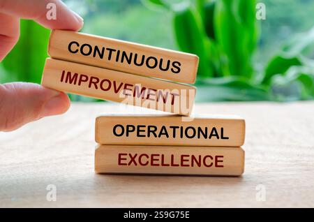 Amélioration continue et texte d'excellence opérationnelle sur blocs de bois. Stratégie commerciale et concept d'amélioration. Banque D'Images