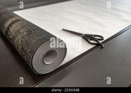 Couper le papier peint avant de le coller au mur, ciseaux, ruban à mesurer et crayon sur la table, couper le papier peint à la taille Banque D'Images