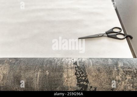Couper le papier peint avant de le coller au mur, ciseaux, ruban à mesurer et crayon sur la table, couper le papier peint à la taille Banque D'Images