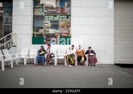 La Mecque, Arabie Saoudite - 13 juin 2024 : pèlerins du Hadj et de l'Oumrah venus d'Indonésie assis devant un hôtel à Makkah, Arabie Saoudite. Hajj 2024. Banque D'Images