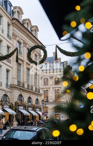 Décorations festives de Noël sur la rue Saint-Honoré à Paris pendant les fêtes de fin d'année 2024, avec guirlandes, lumières et architecture élégante. Banque D'Images