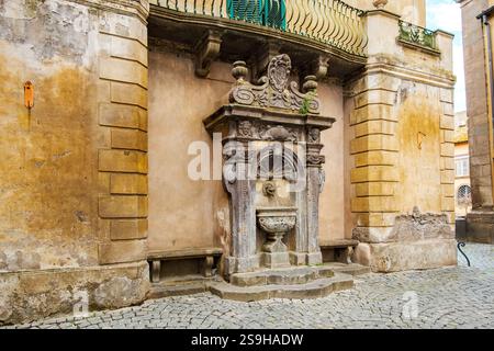 Fontaine ancienne embellissant l'architecture historique de Tuscania en Italie Banque D'Images