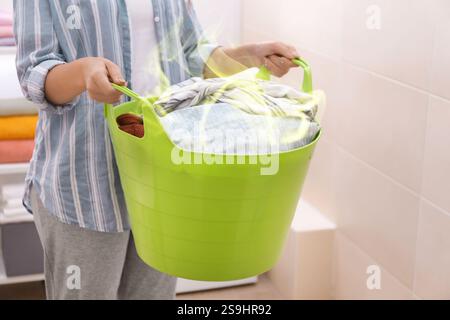 Femme tenant un panier avec du linge sale à la maison Banque D'Images