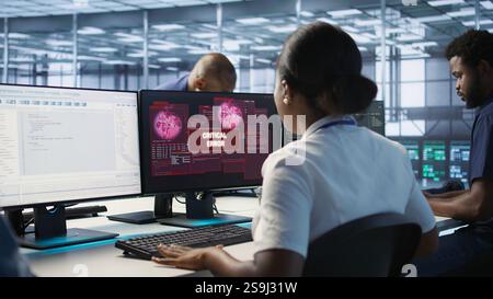 Femme voyant une erreur critique sur l'écran du PC dans le centre de données, demandant l'aide de l'équipe de cybersécurité. Employé voyant des incidents de sécurité affectant le système réseau de la salle des serveurs, caméra A. Banque D'Images