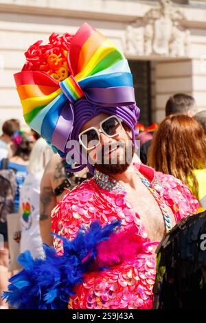Drag queen barbu avec arc-en-ciel cplourful sur chapeau et haut rose à Birmingham Pride célébrant la diversité et l'égalité LGBT+ Banque D'Images