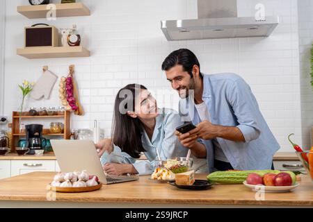 Heureux jeune couple caucasien excité se sentent euphorique avec un bon email, obtenez une offre de vente incroyable ou une offre de réduction sur ordinateur. Homme millénaire ravi et Banque D'Images