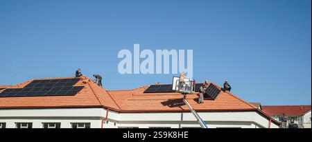 Sibiu, Roumanie - 12 novembre 2024. les ouvriers installent des panneaux photovoltaïques sur le toit Banque D'Images
