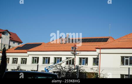 Sibiu, Roumanie - 12 novembre 2024. les ouvriers installent des panneaux photovoltaïques sur le toit Banque D'Images