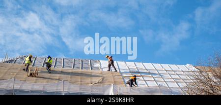 Sibiu, Roumanie - 12 novembre 2024. les ouvriers installent des panneaux photovoltaïques sur le toit Banque D'Images