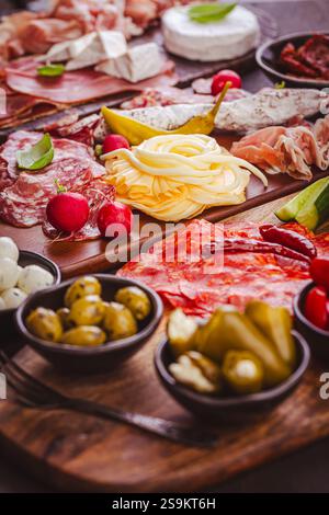 Hors-d'œuvre assortis et plateaux d'antipasti sur plateau en bois, concept traiteur avec viandes et fromages Banque D'Images
