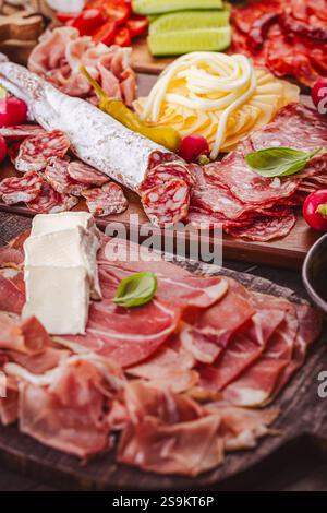 Hors-d'œuvre assortis et plateaux d'antipasti sur plateau en bois, concept traiteur avec viandes et fromages Banque D'Images