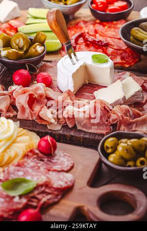 Hors-d'œuvre assortis et plateaux d'antipasti sur plateau en bois, concept traiteur avec viandes et fromages Banque D'Images