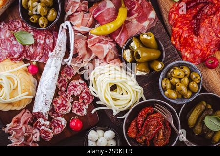 Hors-d'œuvre assortis et plateaux d'antipasti sur plateau en bois, concept traiteur avec viandes et fromages Banque D'Images