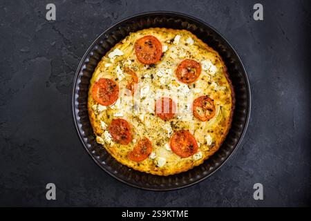 Crustless vegetarian pie with eggs, tomato, basil and cheese, quiche or omelet in a pan Banque D'Images