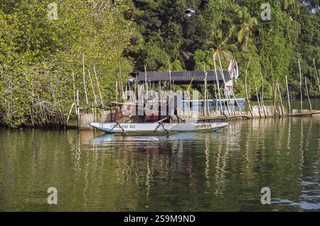 Image sans visage d'un pêcheur dos à la caméra se préparant à pêcher sur son bateau-canot Oruwa propulsé par une rame en saillie sri-lankaise Banque D'Images