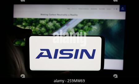 Allemagne. 25 octobre 2024. Dans cette illustration photo, une personne tient un téléphone portable avec le logo de la société automobile japonaise Aisin Corporation sur l'écran devant la page Web. (Crédit image : © timon Schneider/SOPA images via ZUMA Press Wire) USAGE ÉDITORIAL SEULEMENT ! Non destiné à UN USAGE commercial ! Banque D'Images