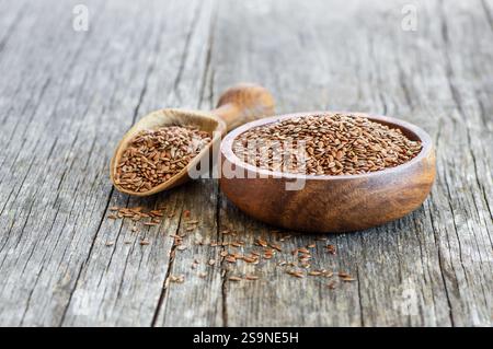 Tas de graines de lin ou de graines de lin dans une cuillère ou un bol sur fond rustique. Concept de graines de lin, fond de fibres alimentaires Banque D'Images