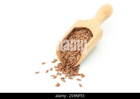 Tas de graines de lin ou de graines de lin dans une pelle en bois isolée sur fond blanc. Concept de graines de lin, fibres alimentaires Banque D'Images