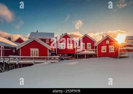 Coucher de soleil sur des maisons de pêcheurs en bois rouge dans le village de Hamnoy, îles Lofoten, Norvège, lumière de coucher de soleil pittoresque Banque D'Images