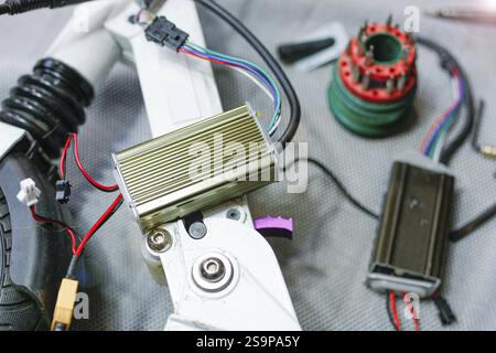 Gros plan des composants électriques et mécaniques d'un scooter, axé sur la réparation et le câblage Banque D'Images