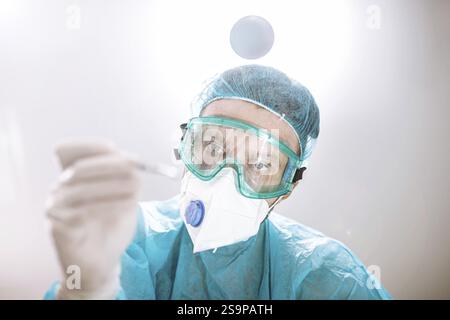 Un professionnel de la santé se concentrant sur une tâche avec un outil à la main Banque D'Images
