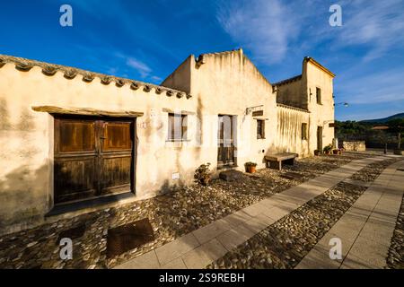 Façades de vieilles maisons avec portes en bois à Tratalias Vecchio à côté d'une petite rue pavée. Banque D'Images