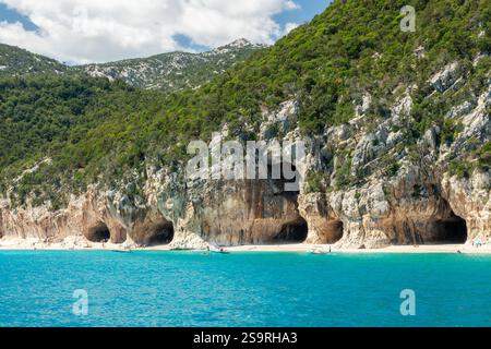 Les gens dans les grottes de la plage de Cala Luna et l'eau bleue transparente claire dans le golfe d'Orosei, île de Sardaigne, Italie Banque D'Images