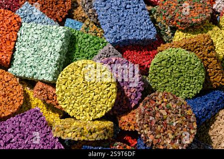 Morceaux de revêtement de sol multicolores fabriqués à partir de miettes de caoutchouc peintes, produits issus du recyclage de vieux pneus de voiture. Gros plan, abstrait géométrique coloré BA Banque D'Images