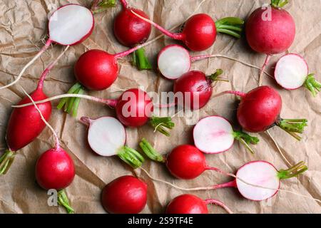 Radis rose biologique de ferme entier et demi frais sur parchemin de gros plan. Photographie culinaire, vue de dessus Banque D'Images