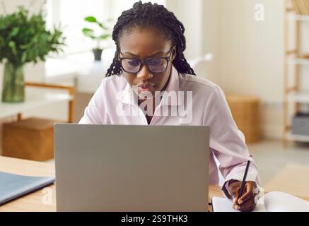 Gros plan portrait d'une femme d'affaires afro-américaine travaillant sur un ordinateur portable au bureau. Banque D'Images