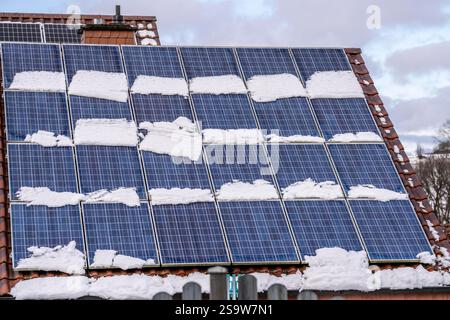 Toit solaire, modules solaires sur un toit, en hiver, partiellement encore recouvert de neige, Rhénanie du Nord-Westphalie, Allemagne, Banque D'Images