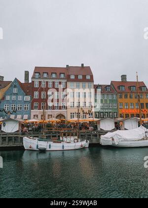 Charmante photographie du port de Nyhavn à Copenhague pendant Noël, capturant l'atmosphère festive avec des bâtiments historiques colorés. Banque D'Images
