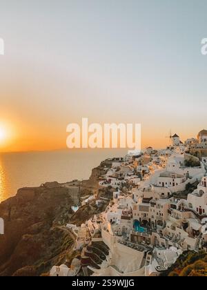 Photographie à couper le souffle d'un coucher de soleil sur Santorin, Grèce, capturant les teintes chaudes et dorées du ciel au coucher du soleil Banque D'Images