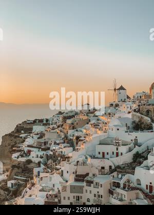 Photographie à couper le souffle d'un coucher de soleil sur Santorin, Grèce, capturant les teintes chaudes et dorées du ciel au coucher du soleil Banque D'Images