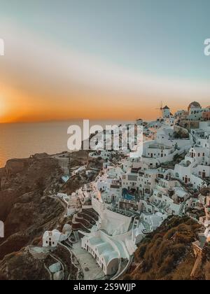 Photographie à couper le souffle d'un coucher de soleil sur Santorin, Grèce, capturant les teintes chaudes et dorées du ciel au coucher du soleil Banque D'Images