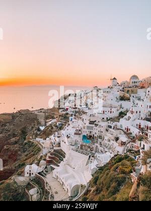 Photographie à couper le souffle d'un coucher de soleil sur Santorin, Grèce, capturant les teintes chaudes et dorées du ciel au coucher du soleil Banque D'Images