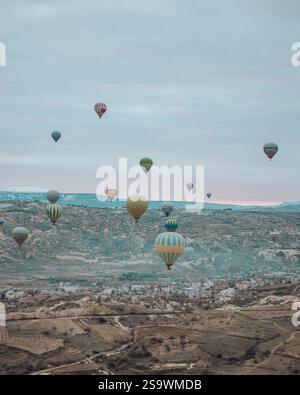 Photographie à couper le souffle de montgolfières survolant le paysage surréaliste de Cappadoce, Turquie, au lever du soleil. Banque D'Images