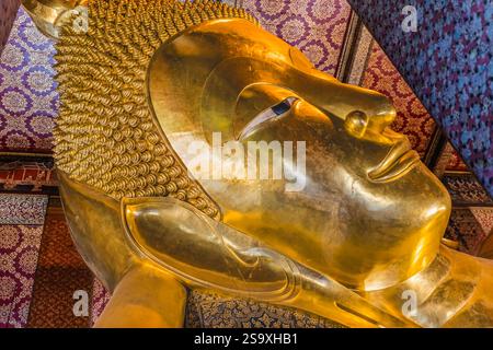 Bouddha couché à visage coloré, temple Wat Pho, Bangkok, Thaïlande. Temple construit dans les années 1600 Bouddha couché construit en 1832. Le visage reflète l'entrée de Bouddha Banque D'Images