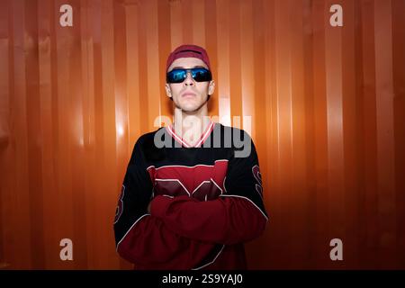 Portrait d'un jeune homme portant des lunettes de soleil avec les bras croisés Banque D'Images
