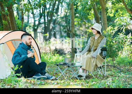 Hommes et femmes appréciant le camping Banque D'Images