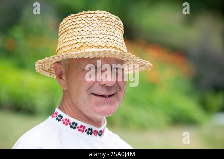 Biélorussie, le village de Lyaskovichi. 20 août 2022. Une célébration des cultures nationales. Portrait d'un biélorusse dans un chapeau de paille. Banque D'Images