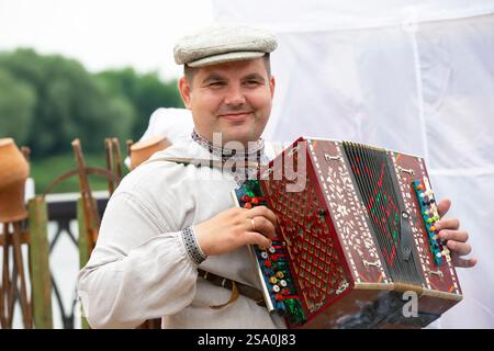 Biélorussie, le village de Lyaskovichi. 20 août 2022. Une célébration des cultures nationales. Portrait d'un biélorusse en vêtements nationaux avec un acco Banque D'Images