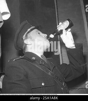 Les années 1940 Un homme vêtu d'uniforme boit de la bière dans une bouteille fabriquée par la brasserie danoise Tuborg. Le slogan immortel et la publicité de la brasserie était : quand un Tuborg a-t-il le meilleur goût? À chaque fois... 1946 Kristoffersson réf. T49-4 Banque D'Images